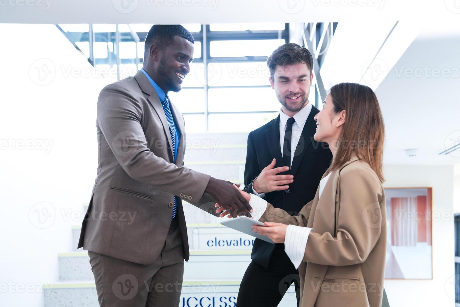 Business people shaking hands. finishing up a meeting. team of business people walk in rush hour at indoor pedestrian stairs and talk together. concept negotiations in feeling successful and happy. photo