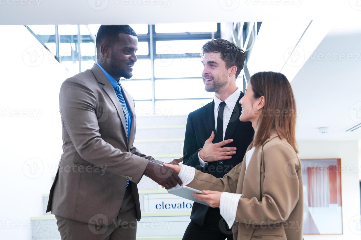 Business people shaking hands. finishing up a meeting. team of business people walk in rush hour at indoor pedestrian stairs and talk together. concept negotiations in feeling successful and happy. photo
