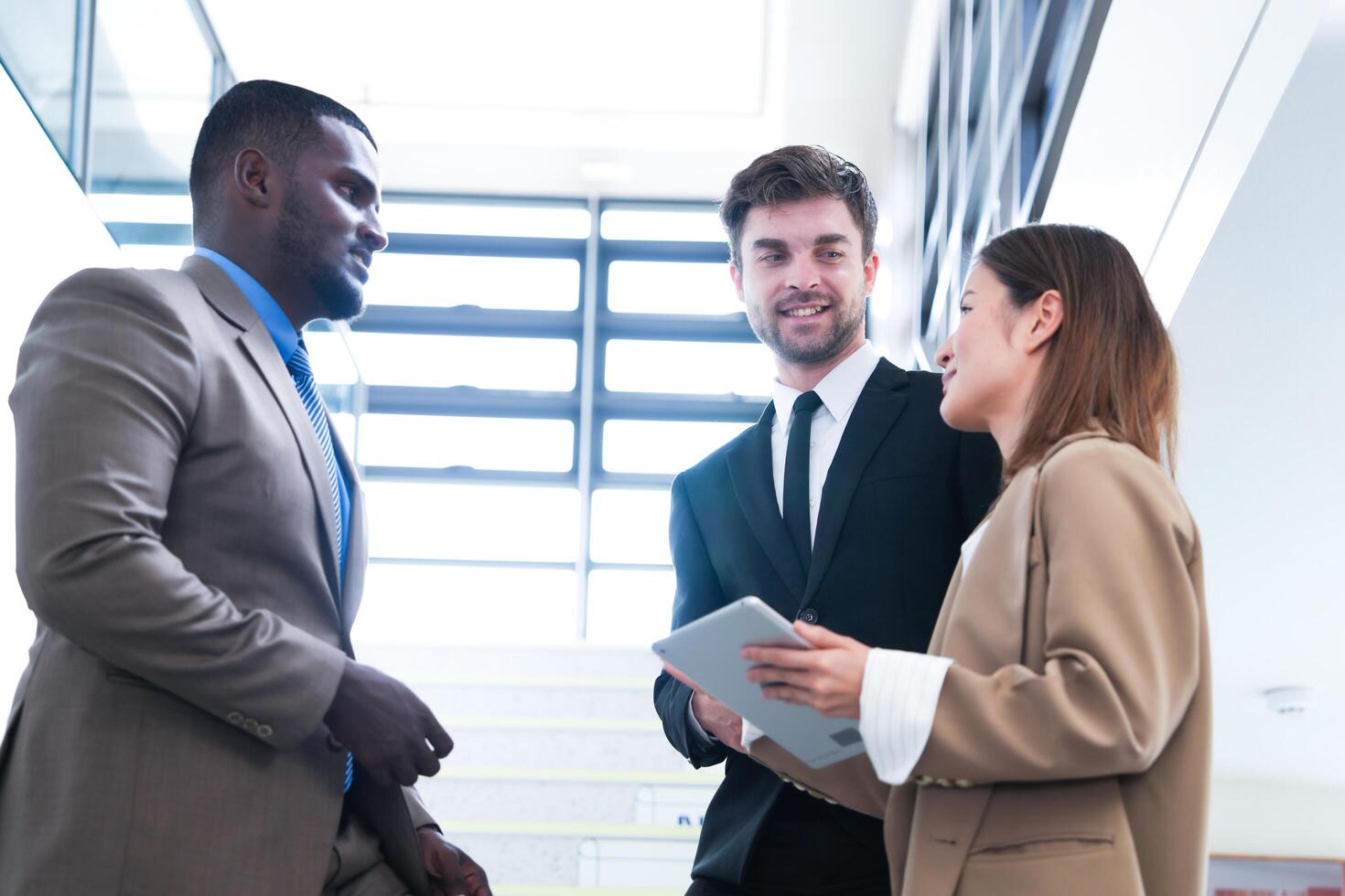 Business people shaking hands. finishing up a meeting. team of business people walk in rush hour at indoor pedestrian stairs and talk together. concept negotiations in feeling successful and happy. photo
