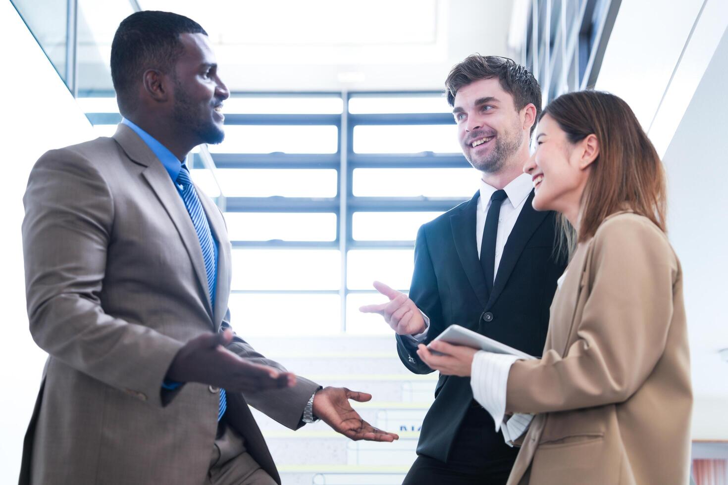 Business people shaking hands. finishing up a meeting. team of business people walk in rush hour at indoor pedestrian stairs and talk together. concept negotiations in feeling successful and happy. photo