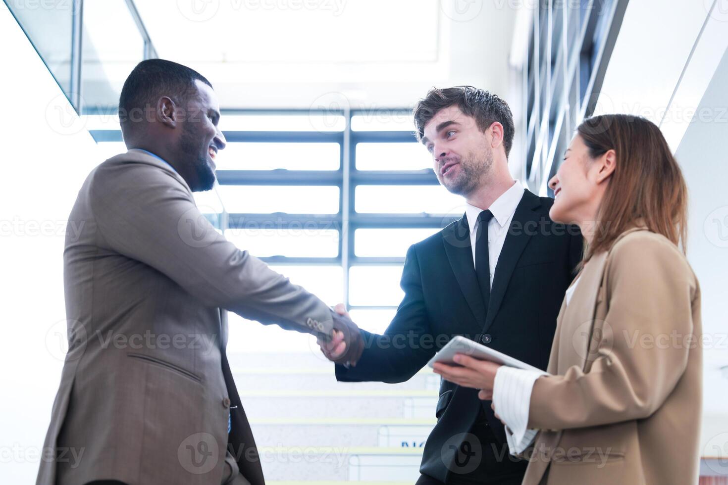 Business people shaking hands. finishing up a meeting. team of business people walk in rush hour at indoor pedestrian stairs and talk together. concept negotiations in feeling successful and happy. photo