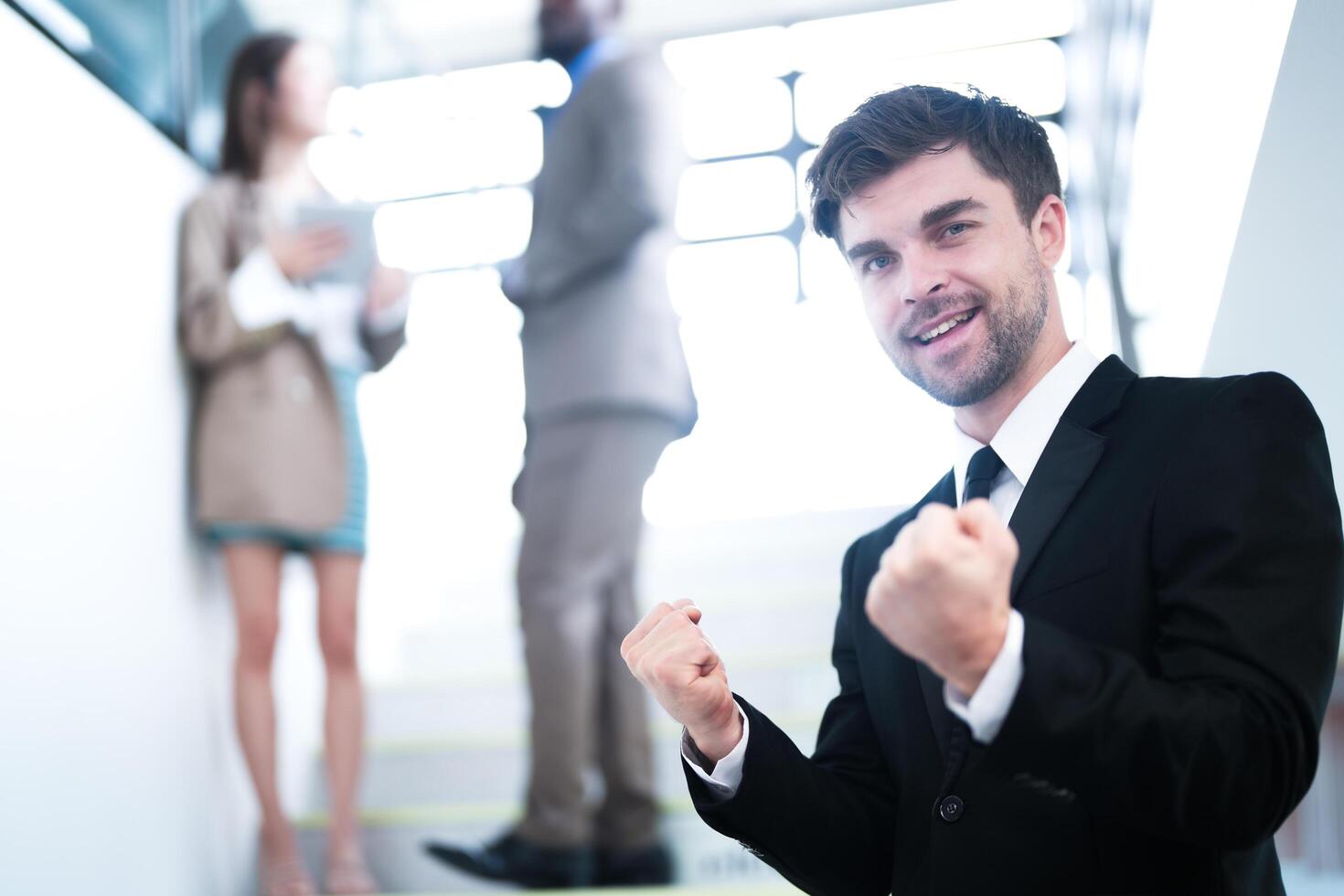 negocio personas y oficina concepto. contento sonriente empresario en oscuro traje. retrato de sonriente medio adulto empresario en pie a corporativo oficina. empresario sonriente con brazos cruzado en oficina. foto