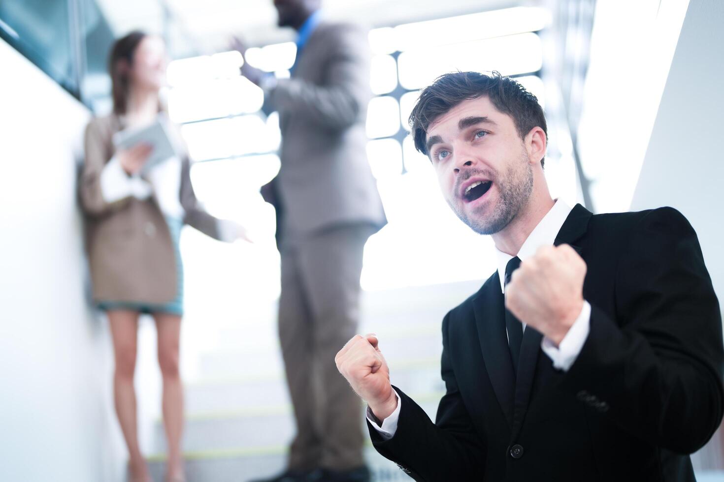 business people and office concept. happy smiling businessman in dark suit. Portrait of smiling mid adult businessman standing at corporate office. Businessman smiling with arms crossed in office. photo