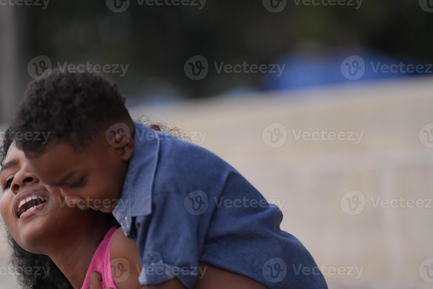 Mixed race African and Asian mother and boy is playing at the outdoor area. smiling happy family have fun running on the beach. portrait of mom and kid lifestyle with a unique hairstyle. photo