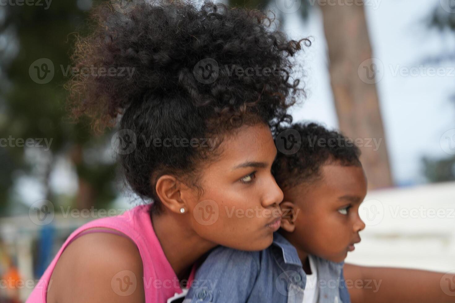 Mixed race African and Asian mother and boy is playing at the outdoor area. smiling happy family have fun running on the beach. portrait of mom and kid lifestyle with a unique hairstyle. photo