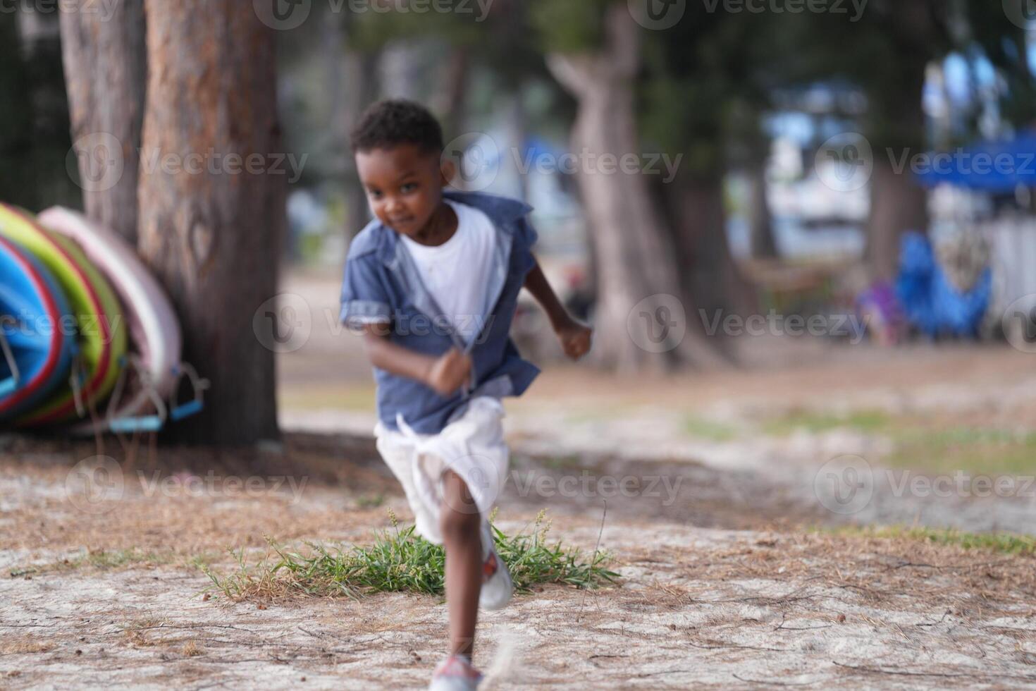 Mixed race African and Asian boy is playing at the outdoor area. smiling happy boy has fun running on the beach. portrait of boy lifestyle with a unique hairstyle. photo