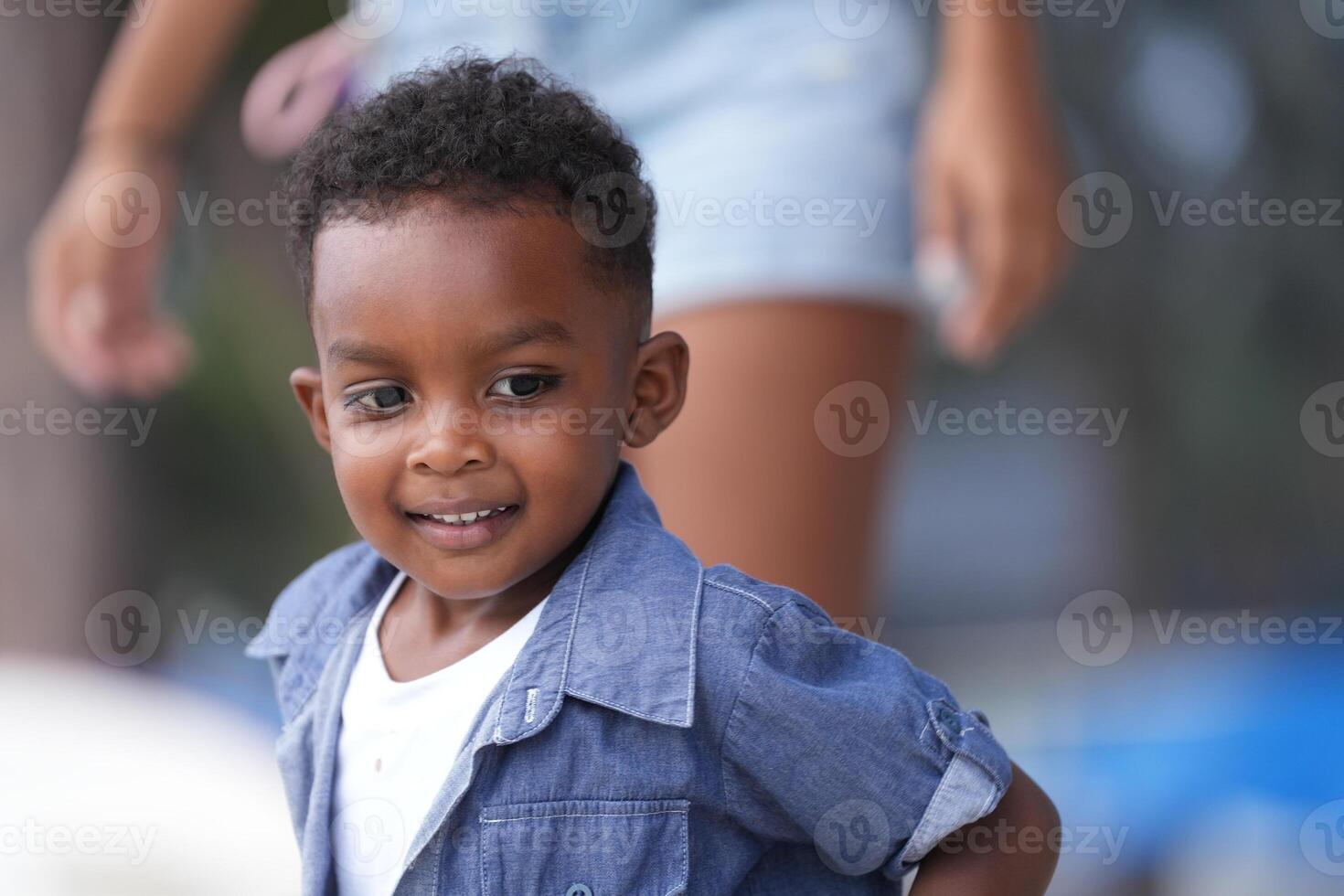 mezclado carrera africano y asiático chico es jugando a el al aire libre área. sonriente contento chico tiene divertido corriendo en el playa. retrato de chico estilo de vida con un único peinado. foto