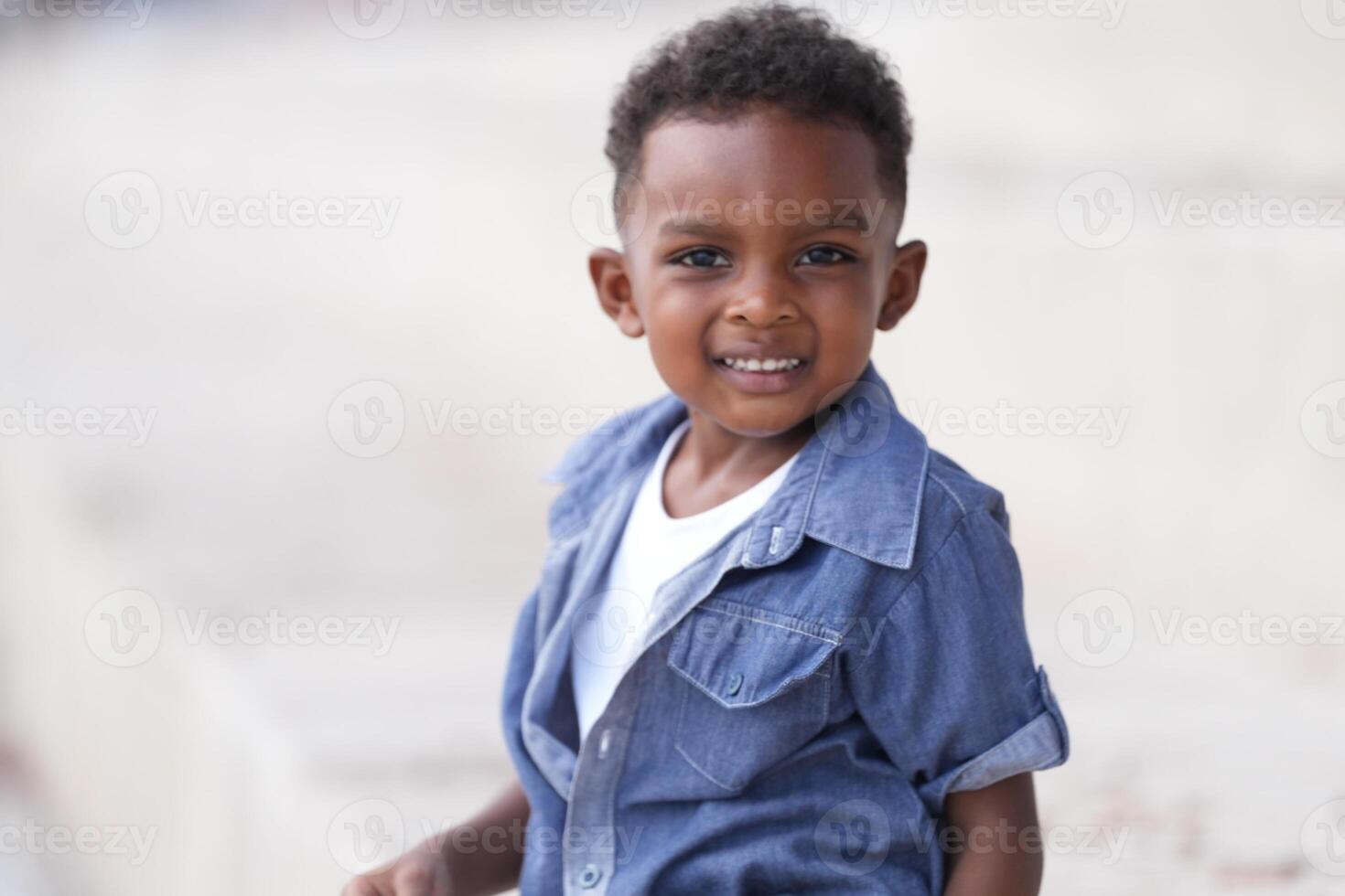 Mixed race African and Asian boy is playing at the outdoor area. smiling happy boy has fun running on the beach. portrait of boy lifestyle with a unique hairstyle. photo