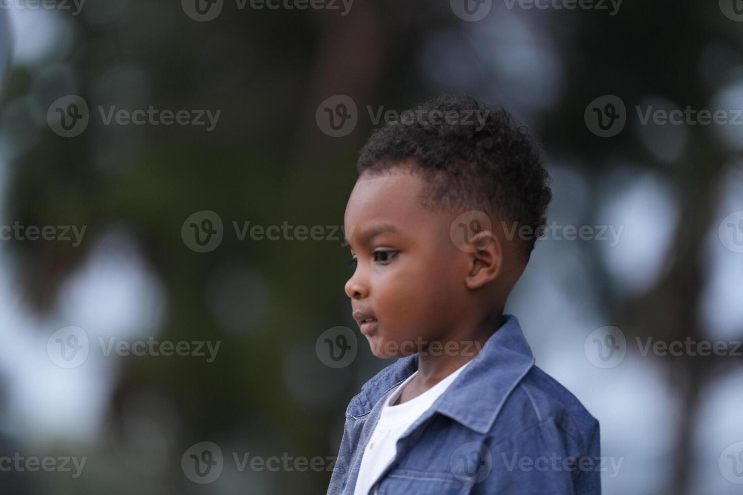 Mixed race African and Asian boy is playing at the outdoor area. smiling happy boy has fun running on the beach. portrait of boy lifestyle with a unique hairstyle. photo
