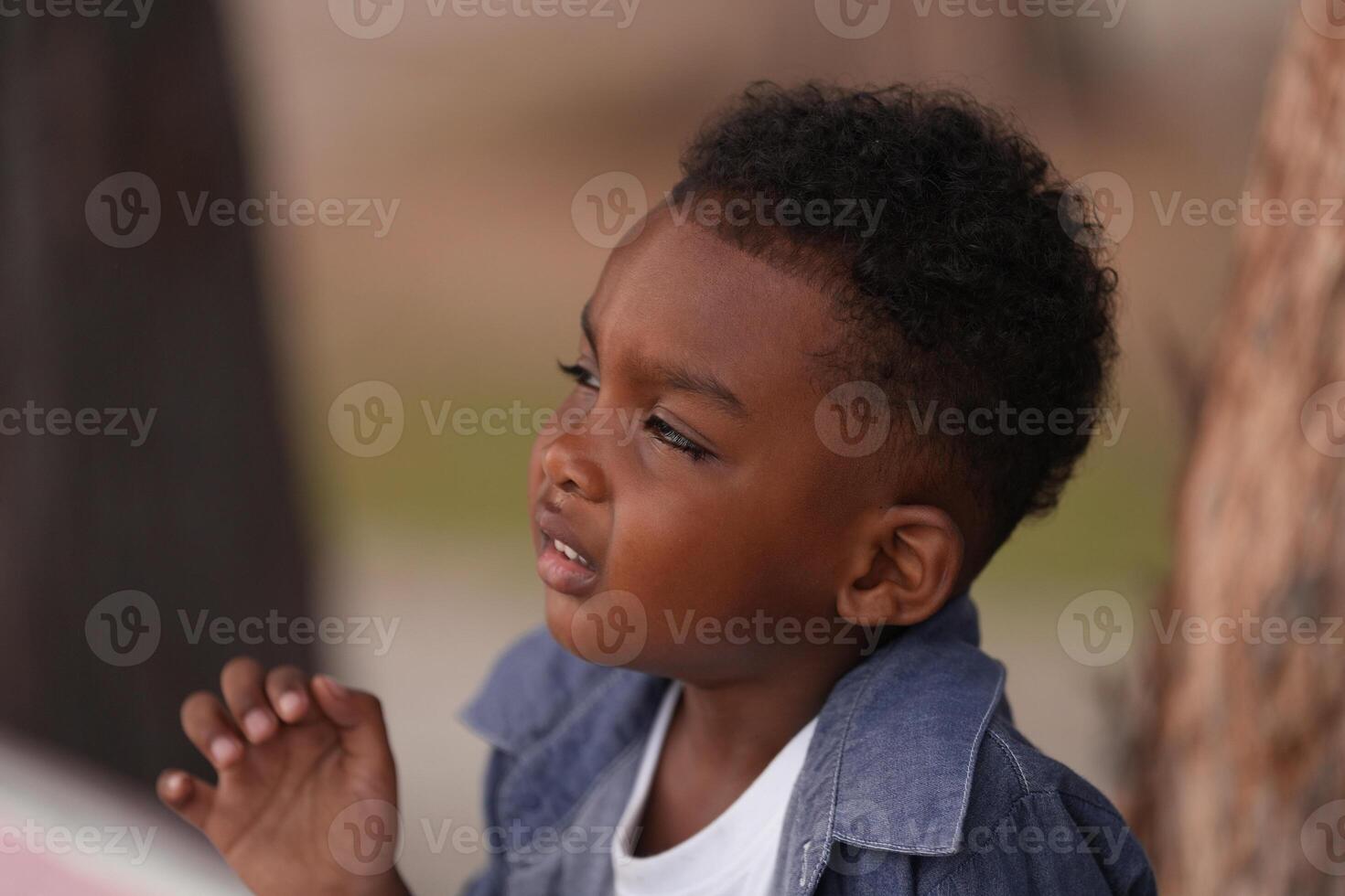 Mixed race African and Asian boy is playing at the outdoor area. smiling happy boy has fun running on the beach. portrait of boy lifestyle with a unique hairstyle. photo