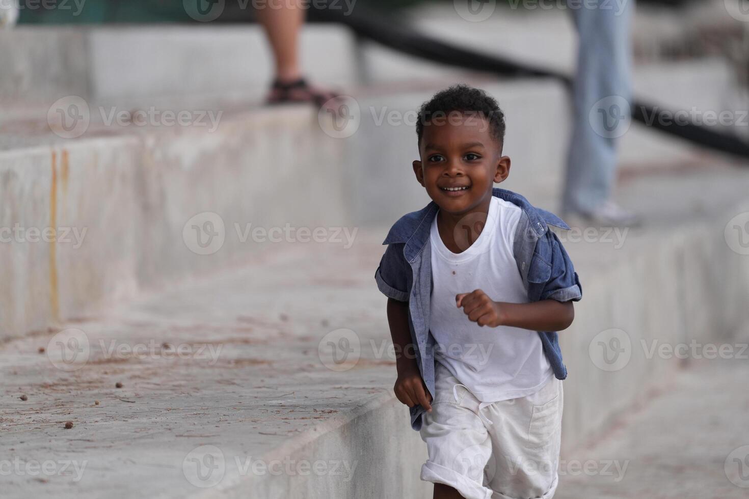 Mixed race African and Asian boy is playing at the outdoor area. smiling happy boy has fun running on the beach. portrait of boy lifestyle with a unique hairstyle. photo