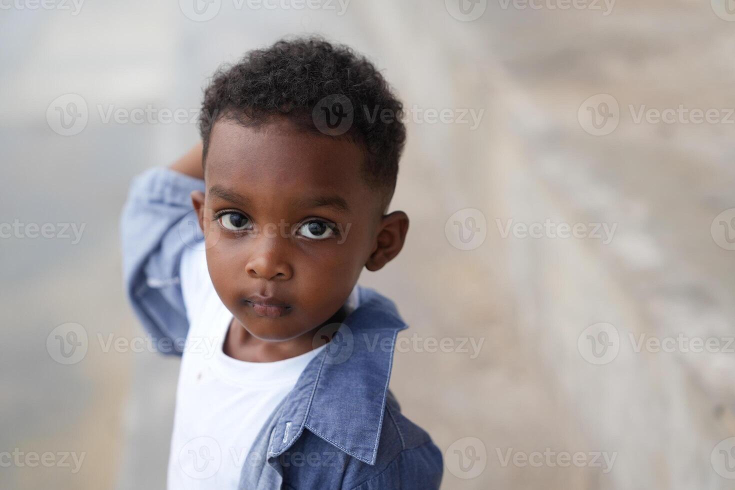 Mixed race African and Asian boy is playing at the outdoor area. smiling happy boy has fun running on the beach. portrait of boy lifestyle with a unique hairstyle. photo