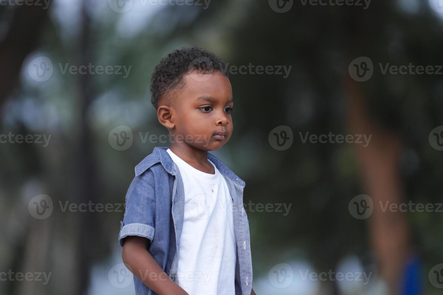 Mixed race African and Asian boy is playing at the outdoor area. smiling happy boy has fun running on the beach. portrait of boy lifestyle with a unique hairstyle. photo