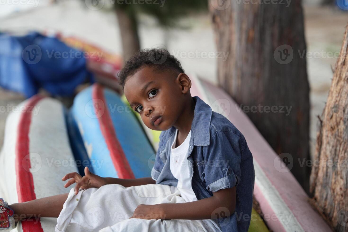 Mixed race African and Asian boy is playing at the outdoor area. smiling happy boy has fun running on the beach. portrait of boy lifestyle with a unique hairstyle. photo