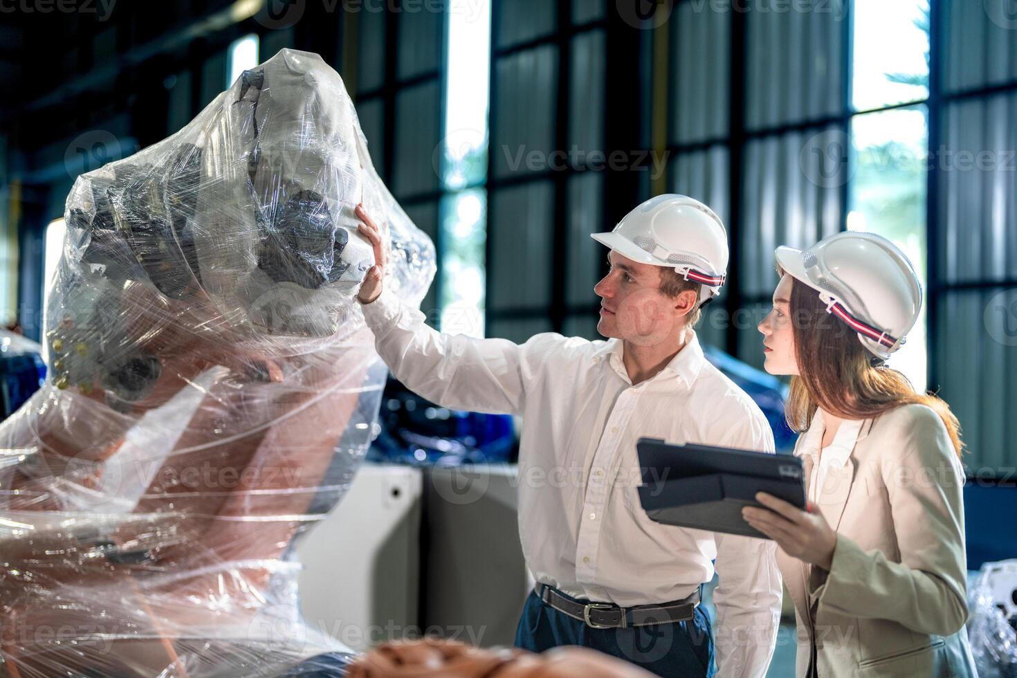 Business engineers meeting and checking new machine robot. Workers walking at warehouse industry welding machine. business negotiation concepts and technology. women Using smart Tablet to present man. photo