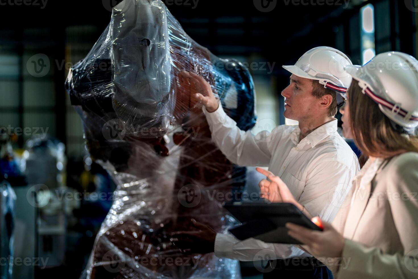 Sales manager and factory owner in suits negotiating selling robots used in the factory. Business engineers meeting and checking new machine robot. Workers walking at warehouse welding machine. photo