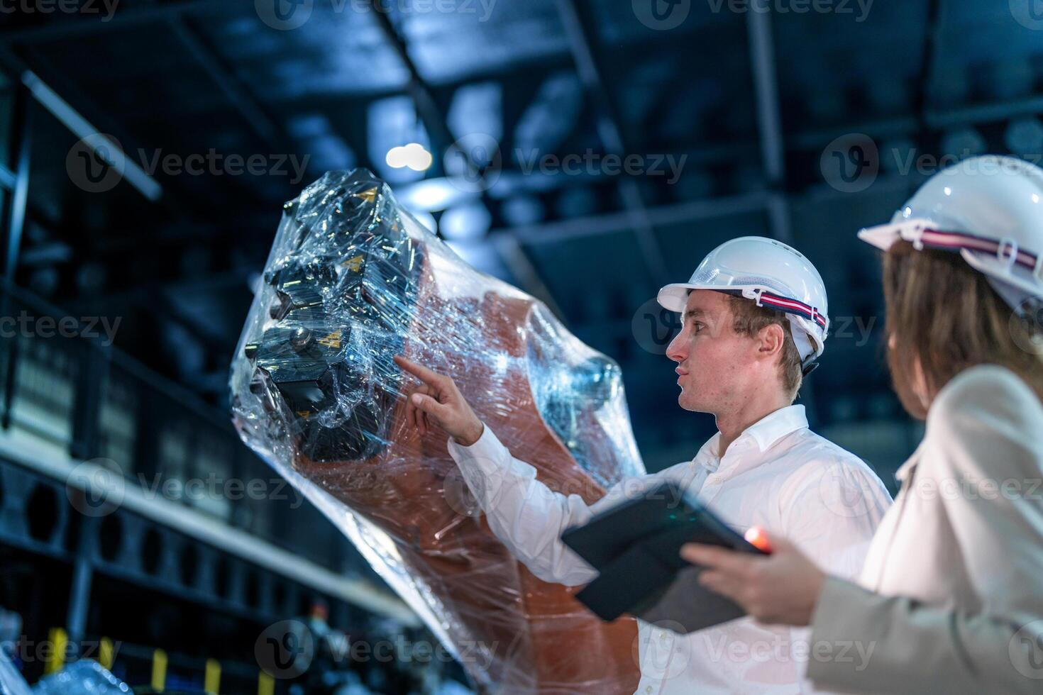 Sales manager and factory owner in suits negotiating selling robots used in the factory. Business engineers meeting and checking new machine robot. Workers walking at warehouse welding machine. photo