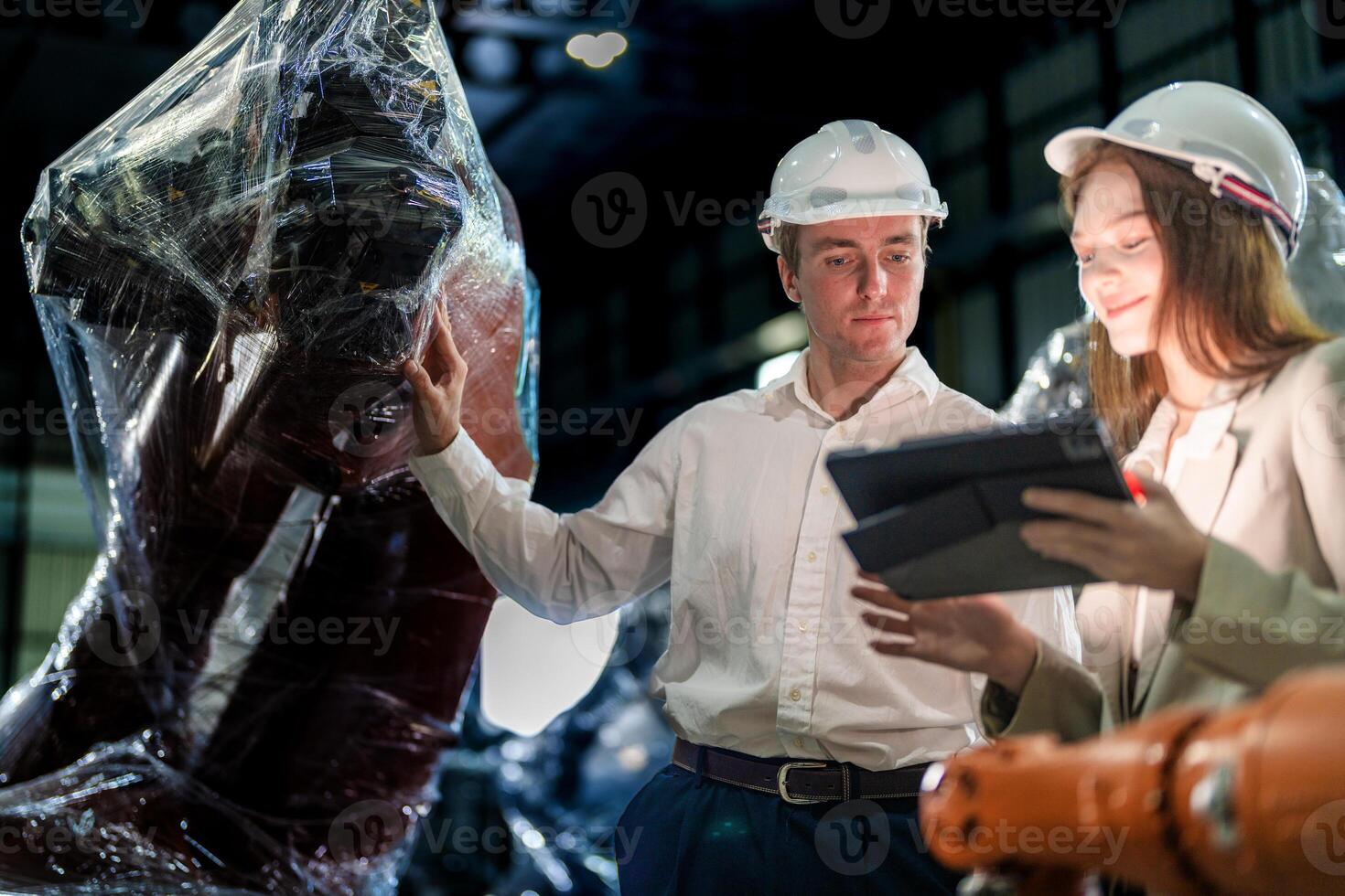 Sales manager and factory owner in suits negotiating selling robots used in the factory. Business engineers meeting and checking new machine robot. Workers walking at warehouse welding machine. photo