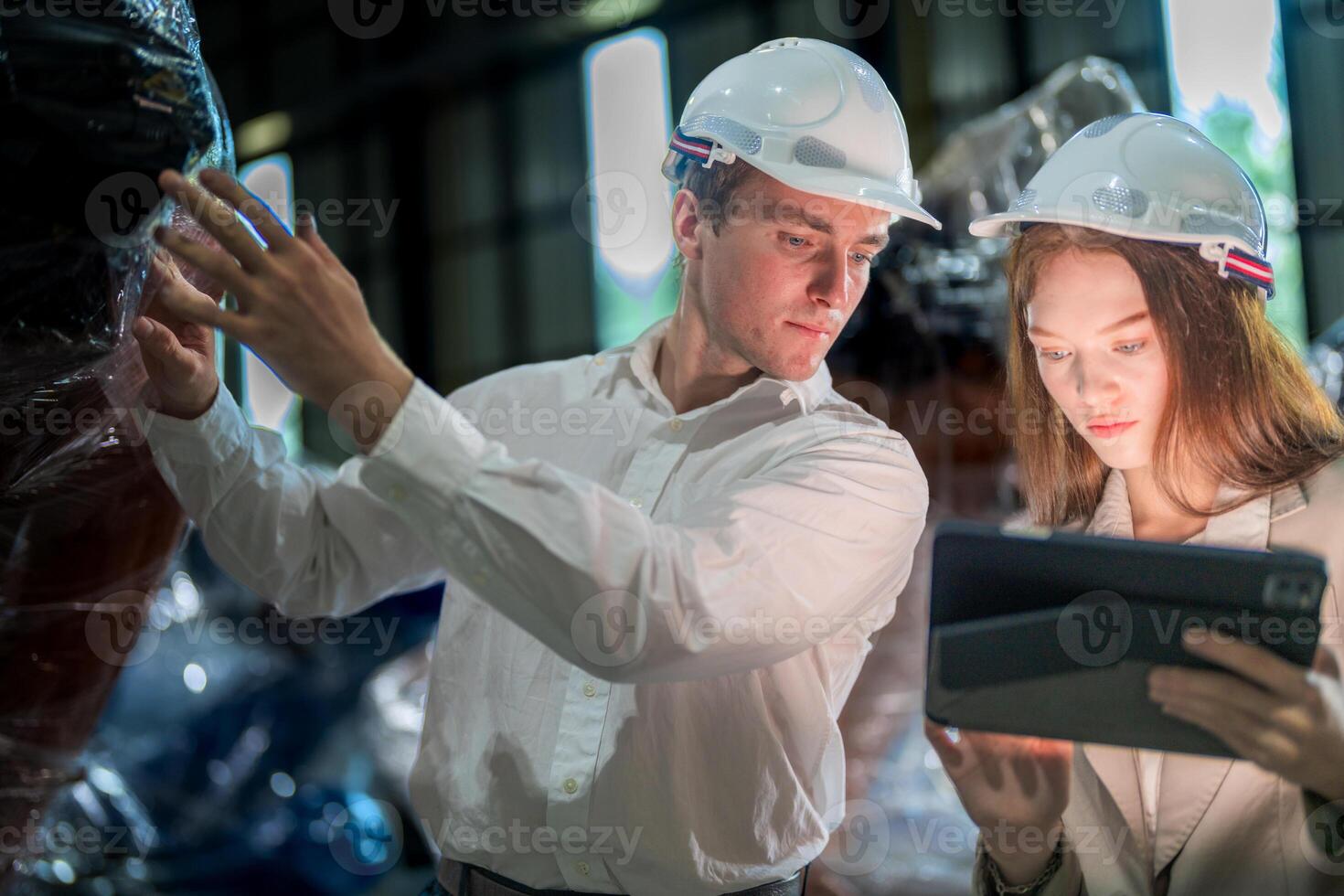 Sales manager and factory owner in suits negotiating selling robots used in the factory. Business engineers meeting and checking new machine robot. Workers walking at warehouse welding machine. photo