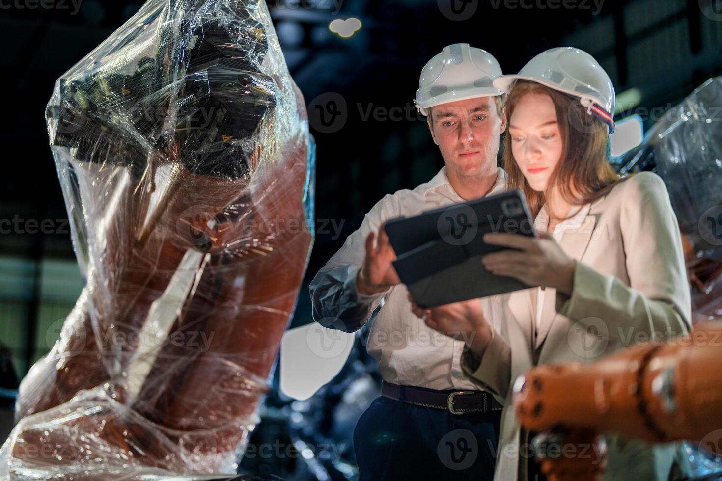 Sales manager and factory owner in suits negotiating selling robots used in the factory. Business engineers meeting and checking new machine robot. Workers walking at warehouse welding machine. photo