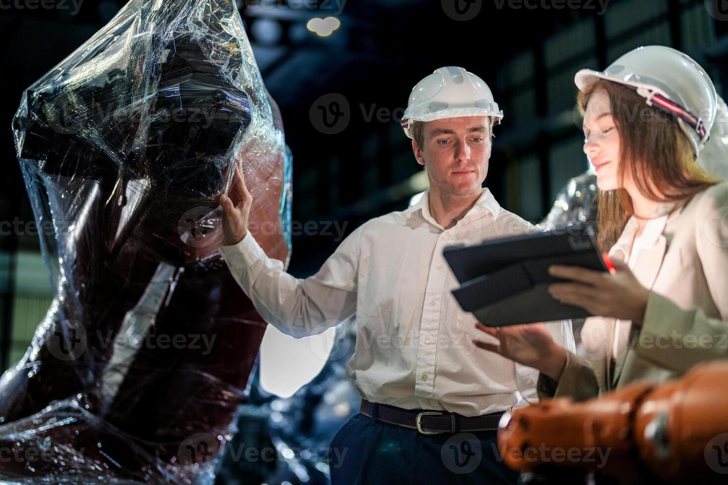 Sales manager and factory owner in suits negotiating selling robots used in the factory. Business engineers meeting and checking new machine robot. Workers walking at warehouse welding machine. photo