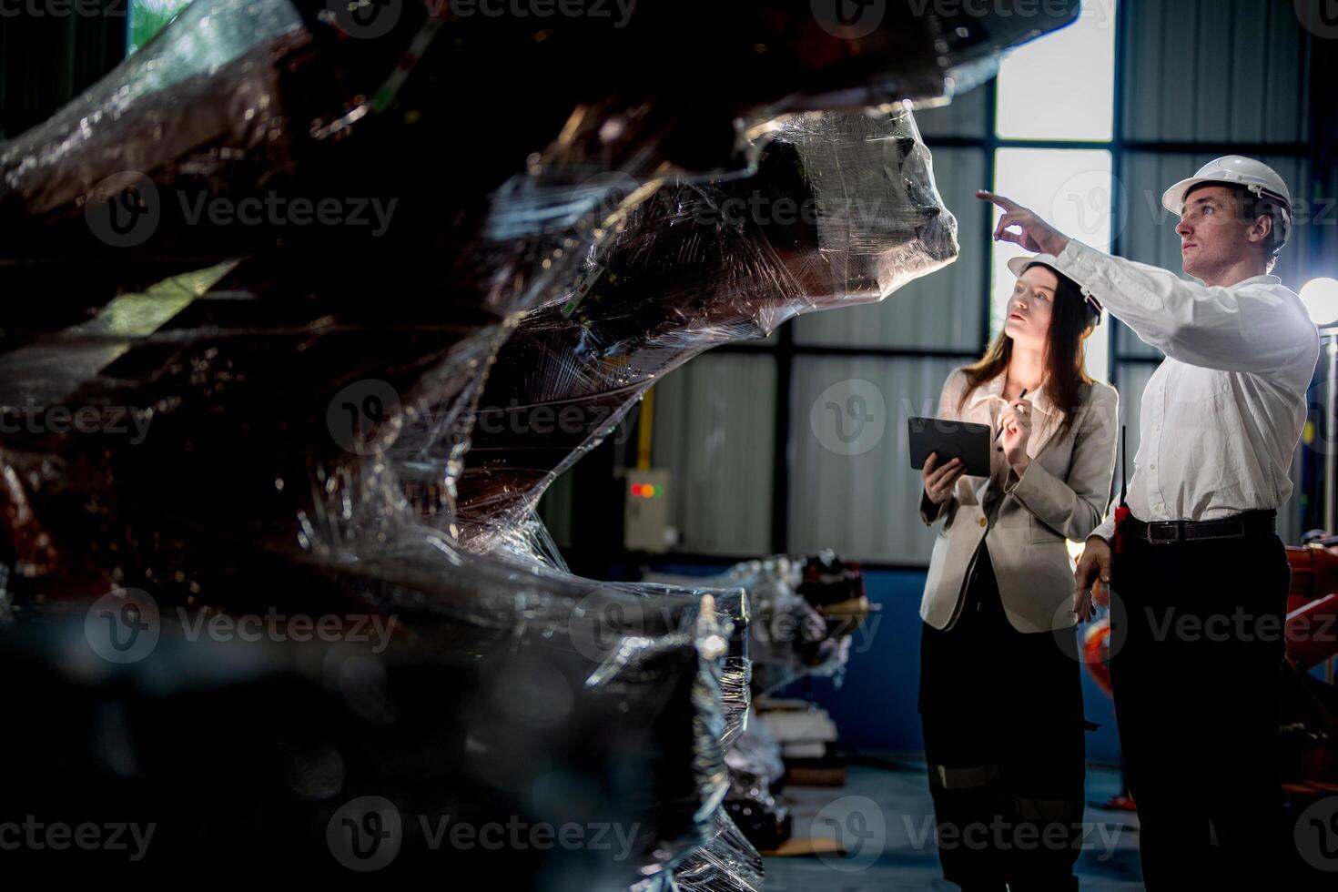 Sales manager and factory owner in suits negotiating selling robots used in the factory. Business engineers meeting and checking new machine robot. Workers walking at warehouse welding machine. photo
