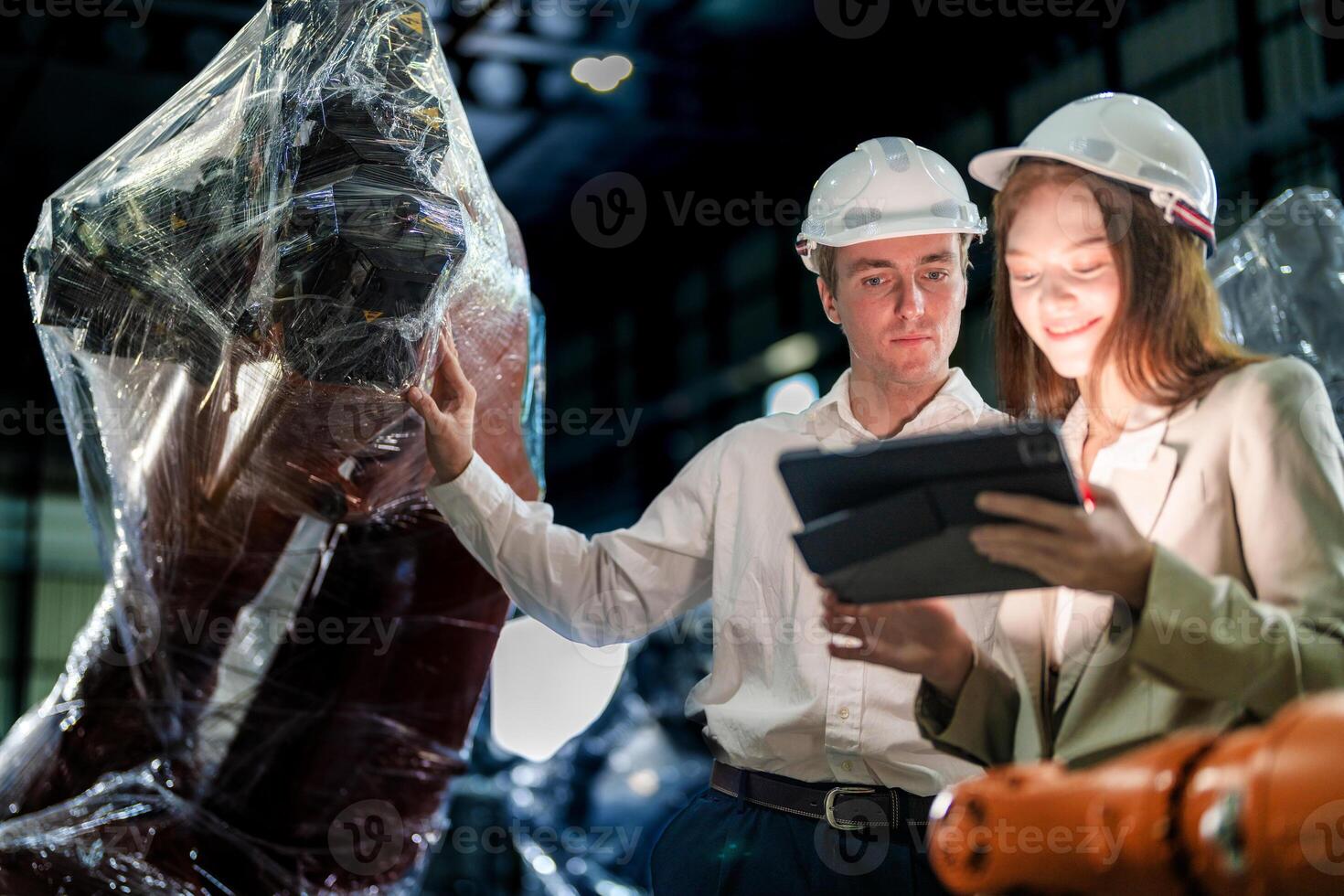 Sales manager and factory owner in suits negotiating selling robots used in the factory. Business engineers meeting and checking new machine robot. Workers walking at warehouse welding machine. photo