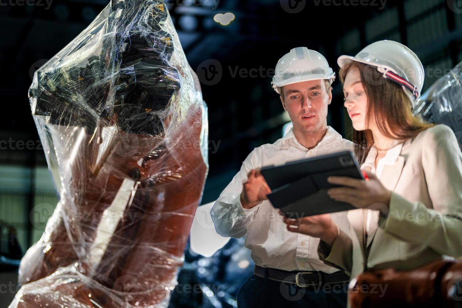 Business engineers meeting and checking new machine robot. Workers walking at warehouse industry welding machine. business negotiation concepts and technology. women Using smart Tablet to present man. photo