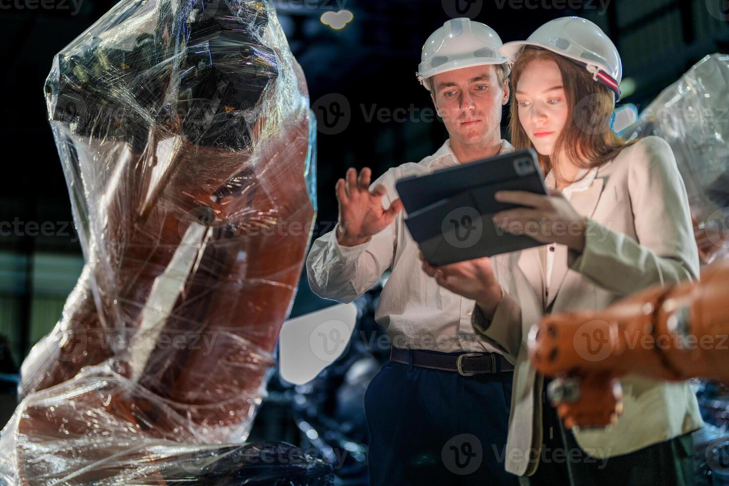 Sales manager and factory owner in suits negotiating selling robots used in the factory. Business engineers meeting and checking new machine robot. Workers walking at warehouse welding machine. photo