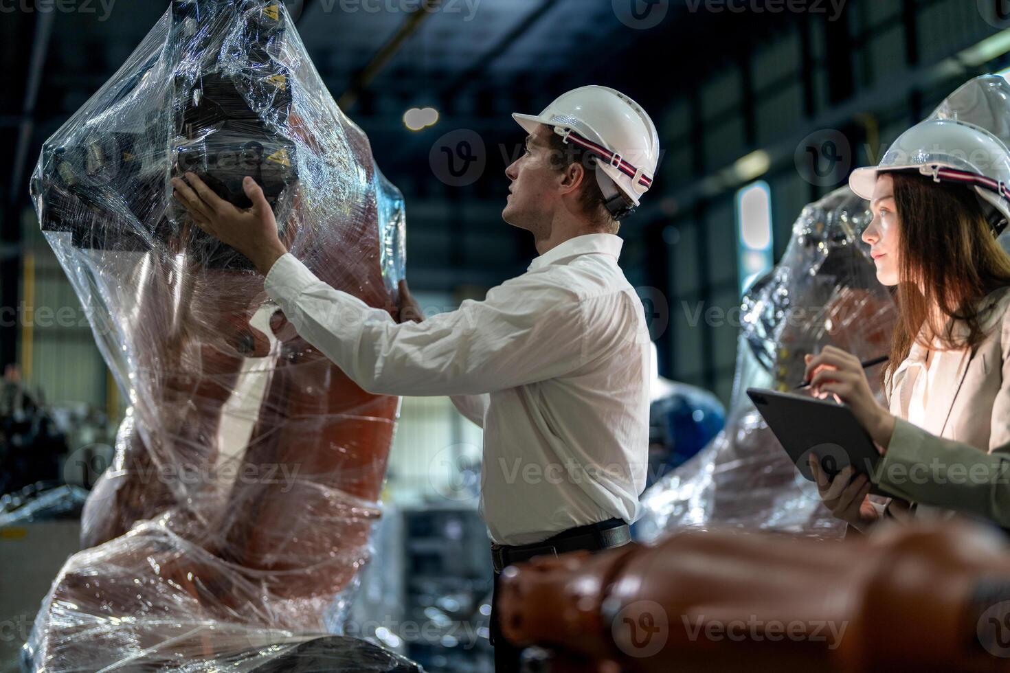 Business engineers meeting and checking new machine robot. Workers walking at warehouse industry welding machine. business negotiation concepts and technology. women Using smart Tablet to present man. photo