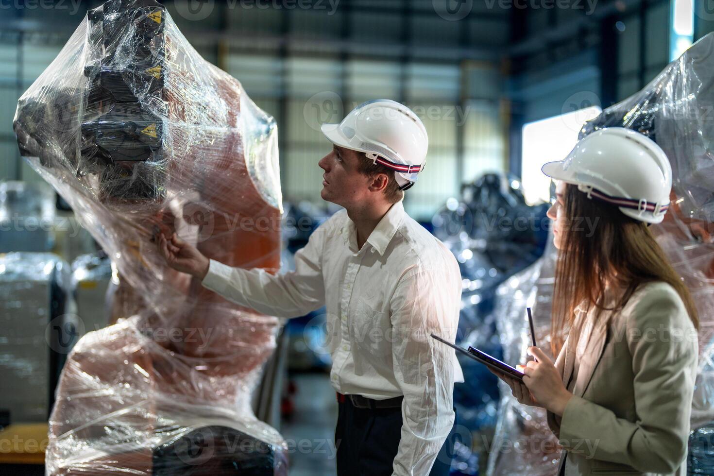 Business engineers meeting and checking new machine robot. Workers walking at warehouse industry welding machine. business negotiation concepts and technology. women Using smart Tablet to present man. photo