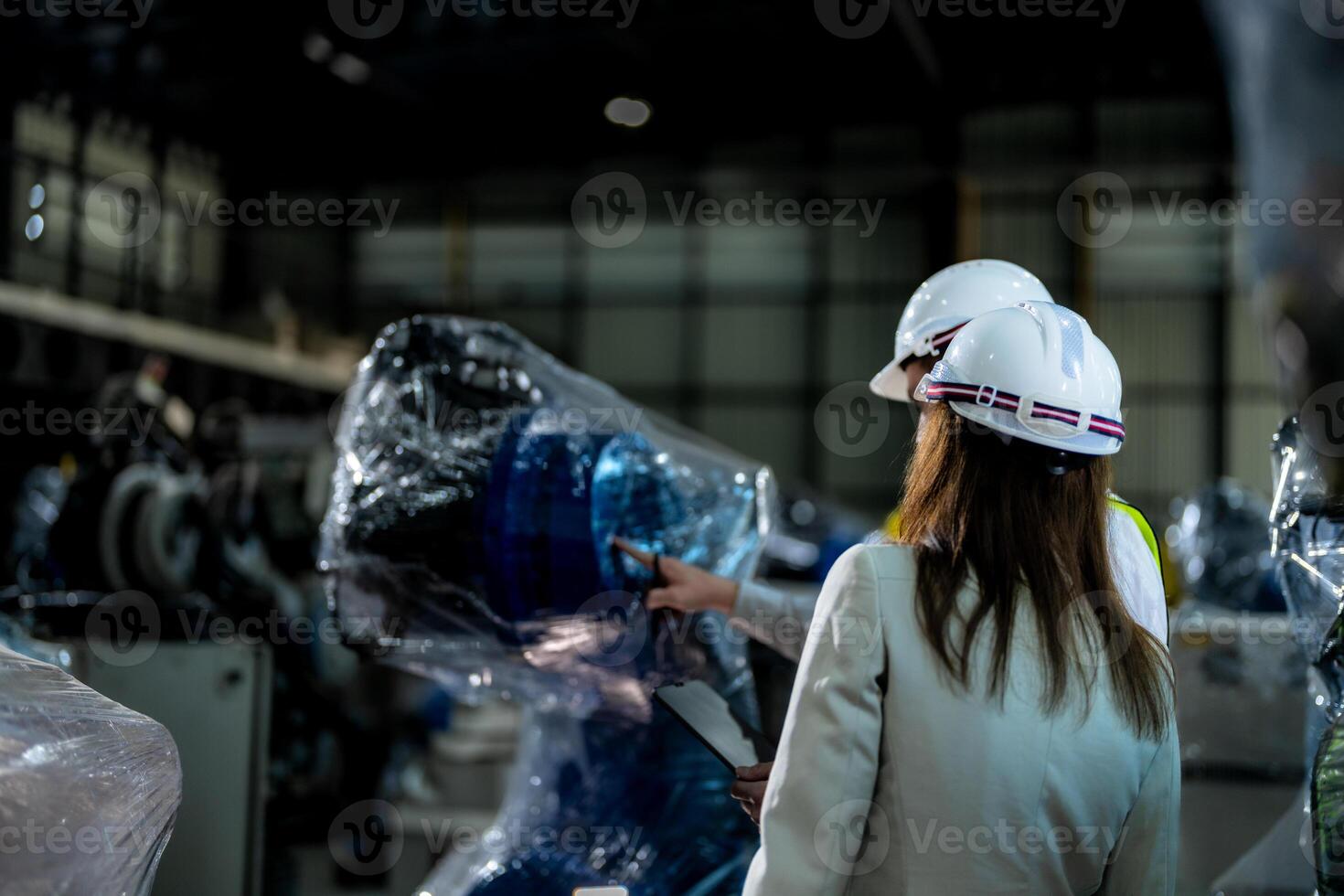 Business engineers meet and check control heavy machine robot arm. Diverse Team of Industrial Robotics Engineers Gathered Around machine. Professional Machinery Operator Use Industrial Digital Tablet. photo