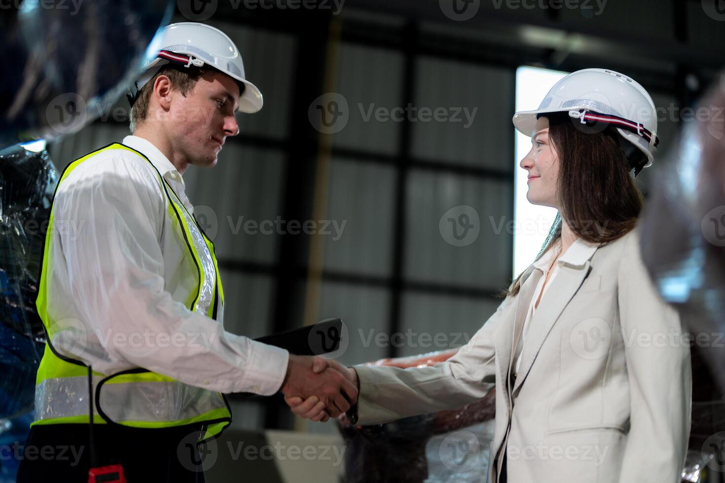 Sales manager and factory owner in suits negotiating selling robots used in the factory. Business engineers meeting and checking new machine robot. Workers walking at warehouse welding machine. photo