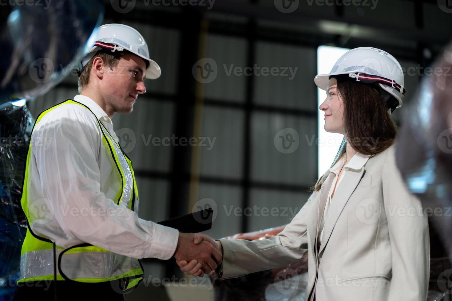 Sales manager and factory owner in suits negotiating selling robots used in the factory. Business engineers meeting and checking new machine robot. Workers walking at warehouse welding machine. photo