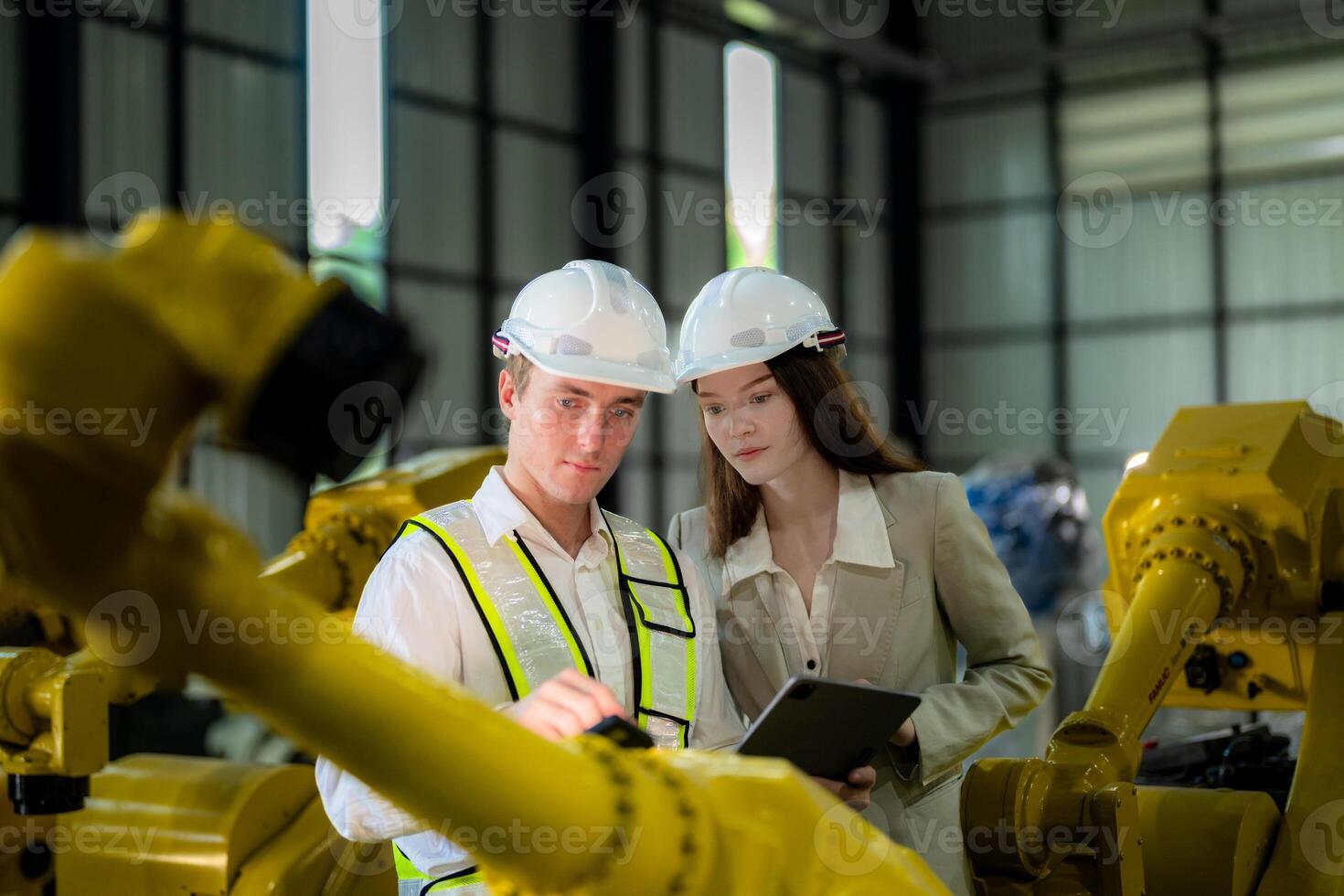 Sales manager and factory owner in suits negotiating selling robots used in the factory. Business engineers meeting and checking new machine robot. Workers walking at warehouse welding machine. photo