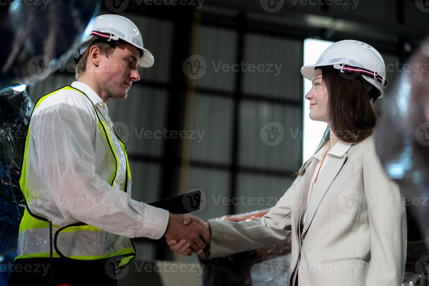 Sales manager and factory owner in suits negotiating selling robots used in the factory. Business engineers meeting and checking new machine robot. Workers walking at warehouse welding machine. photo