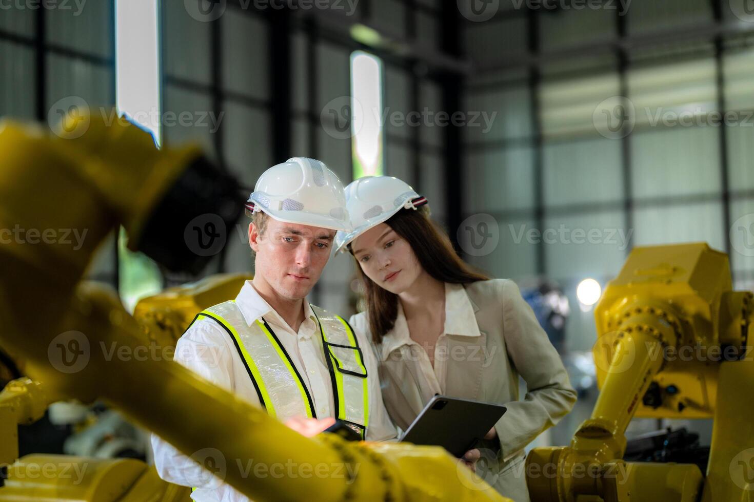 Sales manager and factory owner in suits negotiating selling robots used in the factory. Business engineers meeting and checking new machine robot. Workers walking at warehouse welding machine. photo
