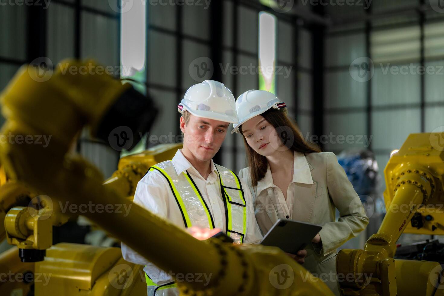 Sales manager and factory owner in suits negotiating selling robots used in the factory. Business engineers meeting and checking new machine robot. Workers walking at warehouse welding machine. photo