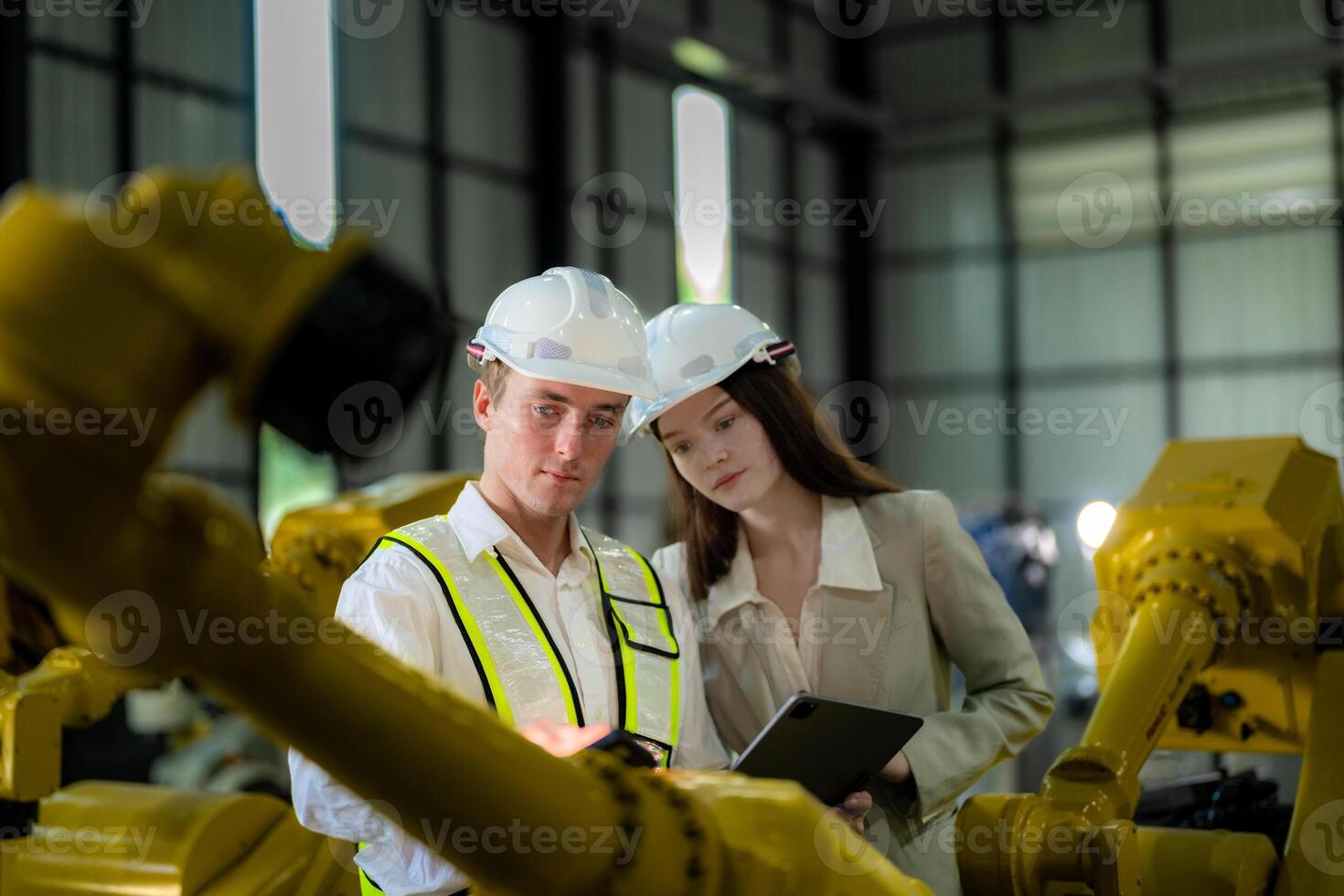 Sales manager and factory owner in suits negotiating selling robots used in the factory. Business engineers meeting and checking new machine robot. Workers walking at warehouse welding machine. photo