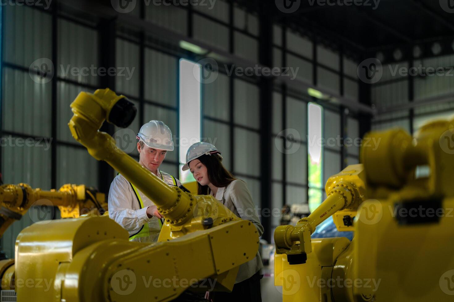 Factory engineers inspecting on machine with smart tablet. Worker works at heavy machine robot arm. The welding machine with a remote system in an industrial factory. Artificial intelligence concept. photo