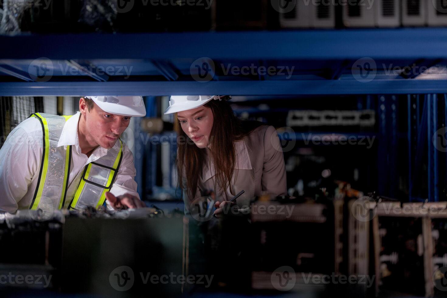 checking and inspecting metal machine part items for shipping. male and woman worker checking the store factory. industry factory warehouse. The warehouse of spare part for machinery and vehicles. photo