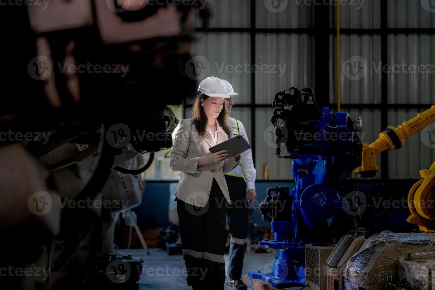 Business woman and man meeting and checking new machine robot. Engineer walking at warehouse industry machine. business negotiation concepts and technology. woman is Using smart Tablet to present man. photo