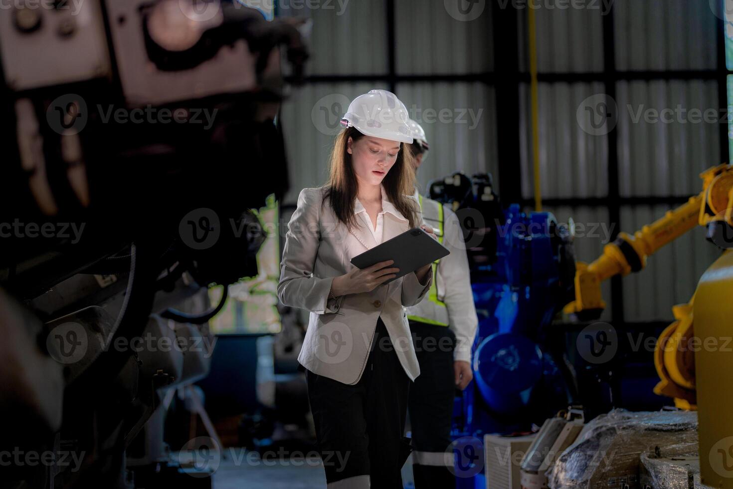 Business woman and man meeting and checking new machine robot. Engineer walking at warehouse industry machine. business negotiation concepts and technology. woman is Using smart Tablet to present man. photo