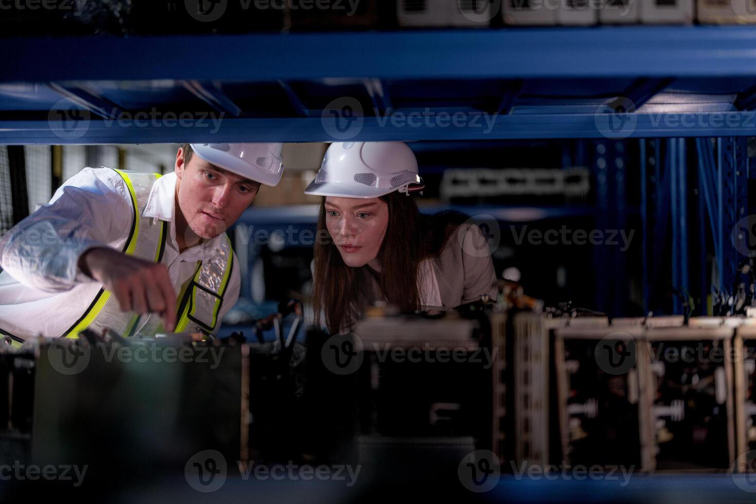 checking and inspecting metal machine part items for shipping. male and woman worker checking the store factory. industry factory warehouse. The warehouse of spare part for machinery and vehicles. photo