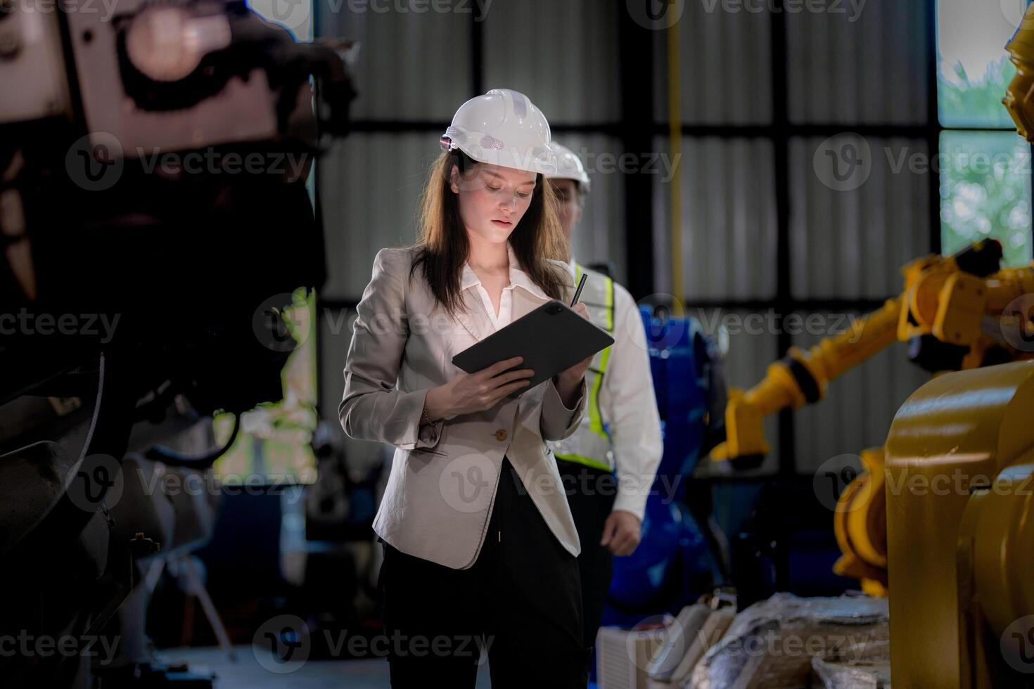 Business woman and man meeting and checking new machine robot. Engineer walking at warehouse industry machine. business negotiation concepts and technology. woman is Using smart Tablet to present man. photo