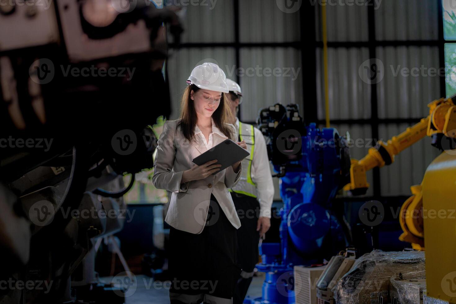 Business woman and man meeting and checking new machine robot. Engineer walking at warehouse industry machine. business negotiation concepts and technology. woman is Using smart Tablet to present man. photo