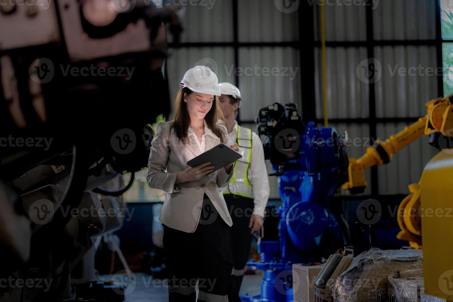 Business woman and man meeting and checking new machine robot. Engineer walking at warehouse industry machine. business negotiation concepts and technology. woman is Using smart Tablet to present man. photo