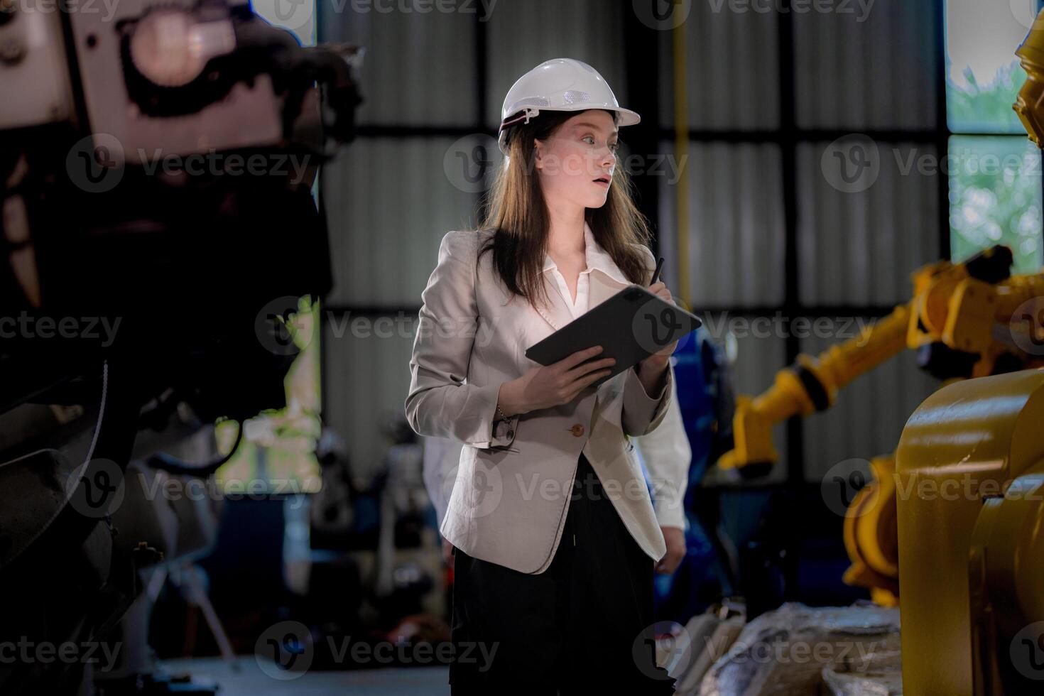 Business woman and man meeting and checking new machine robot. Engineer walking at warehouse industry machine. business negotiation concepts and technology. woman is Using smart Tablet to present man. photo