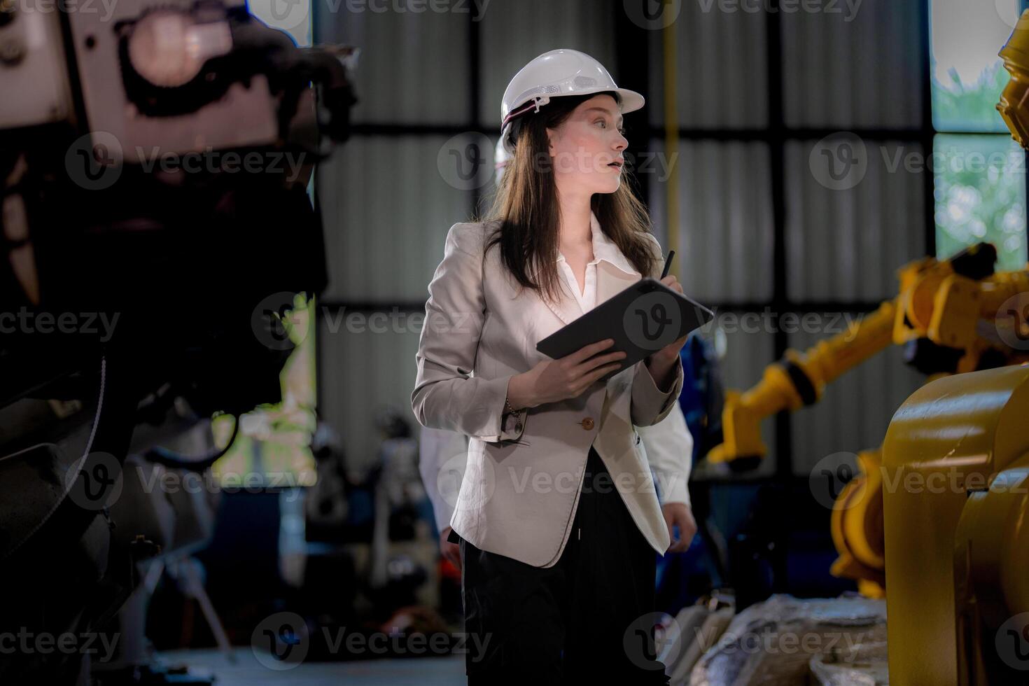 Business woman and man meeting and checking new machine robot. Engineer walking at warehouse industry machine. business negotiation concepts and technology. woman is Using smart Tablet to present man. photo