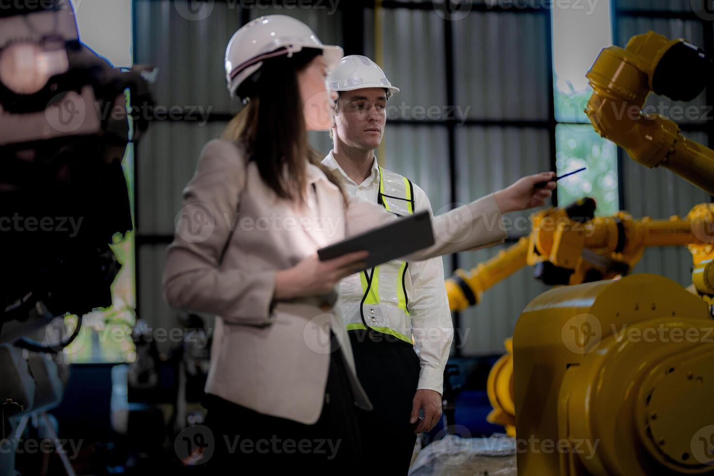 Business woman and man meeting and checking new machine robot. Engineer walking at warehouse industry machine. business negotiation concepts and technology. woman is Using smart Tablet to present man. photo